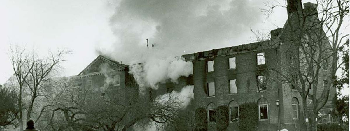 Black and white photograph of Jefferson Hall with smoke billowing out the second and third floor windows