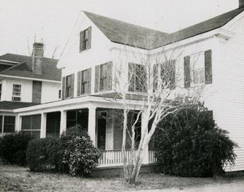 Two story white house with wrap-around covered porch