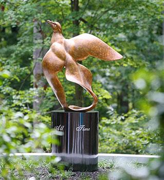 Bronze sculpture of a dove in flight