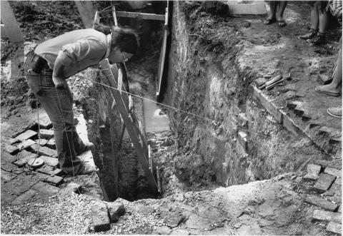 Workers examine the exposed foundation of the Wren Building