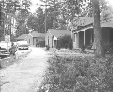 Three of the campus Lodges with a 1950s era cars parked out front