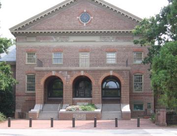 Two story brick building with three arches at the entrance