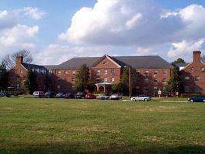 Several three story brick buildings arranged in a U shape with large central field