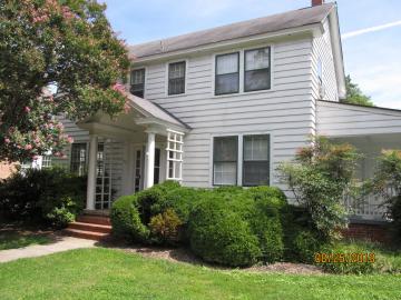 Two story white house with covered entrance and side porch