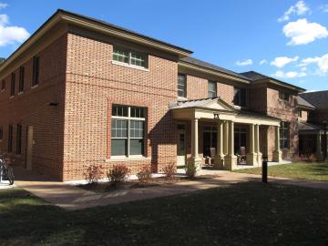 Side view of the entrance to a two story brick house with covered entrance