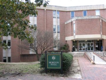 The front entrance of Morton Hall, a three story brick building with ramp leading to the double door entry.