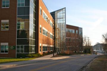 Three story brick building with glass enclosed central staircase